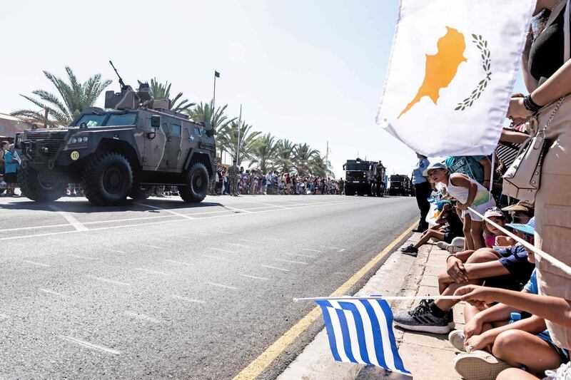 (FILES) In this file photo taken on October 1, 2019 Greek (C) and Cypriot (R) national flags wave as military trucks takes part in a military parade marking the 59th anniversary of Cyprus' independence from British colonial rule, in the capital Nicosia. The United States said on July 8, 2020 it plans to conduct military training with Cyprus for the first time, a step that could anger NATO ally Turkey. The US Congress last year ended a decades-long arms embargo on the island, whose northern third is occupied by Turkey.
 / AFP / Iakovos Hatzistavrou
