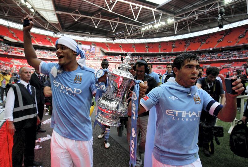 LONDON, ENGLAND - MAY 14:  Vincent Kompany (L) and Carlos Tevez of Manchester City celebrate with the trophy following the FA Cup sponsored by E.ON Final match between Manchester City and Stoke City at Wembley Stadium on May 14, 2011 in London, England.  (Photo by Alex Livesey/Getty Images)
