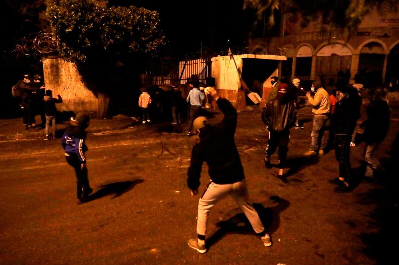 Lebanese anti-government protesters hurl rocks at the municipality building in the northern city of Tripoli. AFP