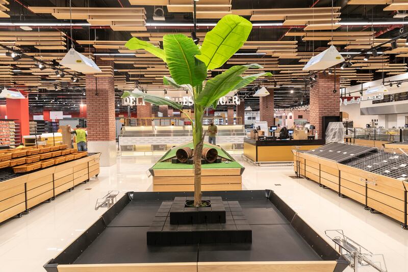 The store has a sleek, modern design with elements of greenery and plenty of wooden materials.