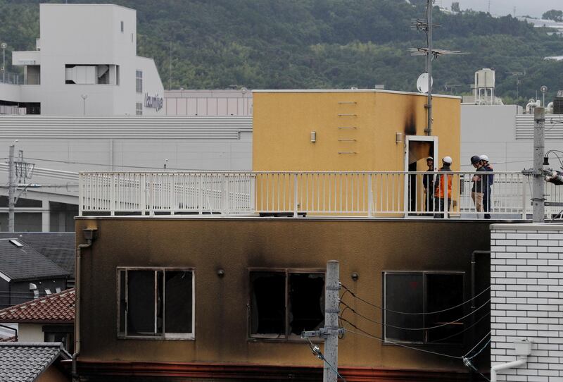 Firefighters check an entrance at the rooftop of the torched building. Reuters