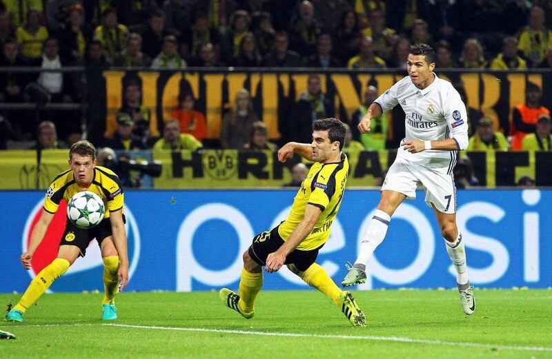 Real Madrid’s Cristiano Ronaldo, right, scores the opener against Borussia Dortmund players Sokratis Papastathopoulos, centre, and Matthias Ginter, left. Ina Fassbender / EPA