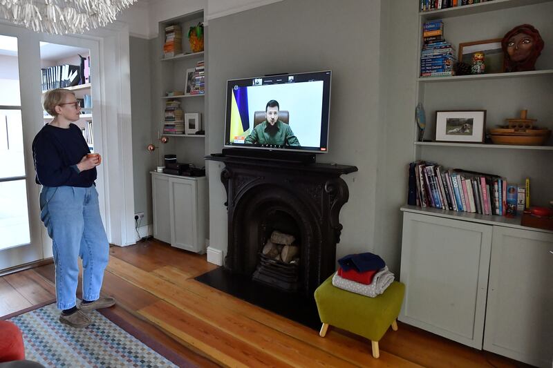 Sally Hasson watches TV at home in Dublin as Mr Zelenskyy appears on screen. Reuters