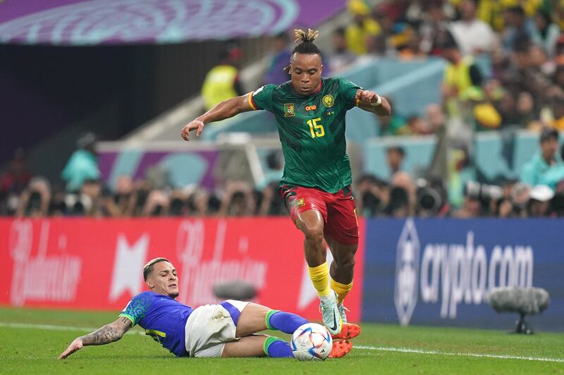 Cameroon's Pierre Kunde skips past past a challenge by Antony of Brazil. PA