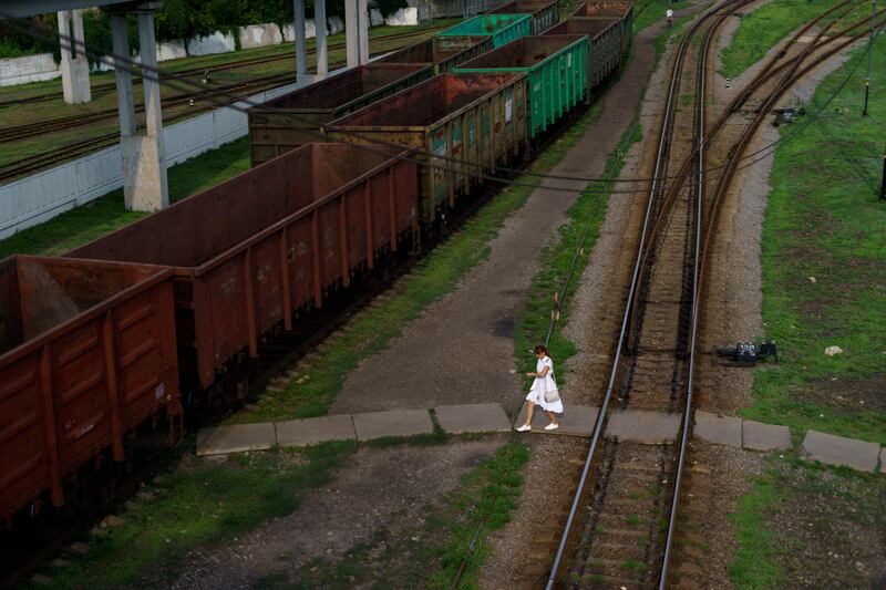 A woman crosses train tracks to reach a residential area of town in Donetsk, eastern Ukraine. AP Photo