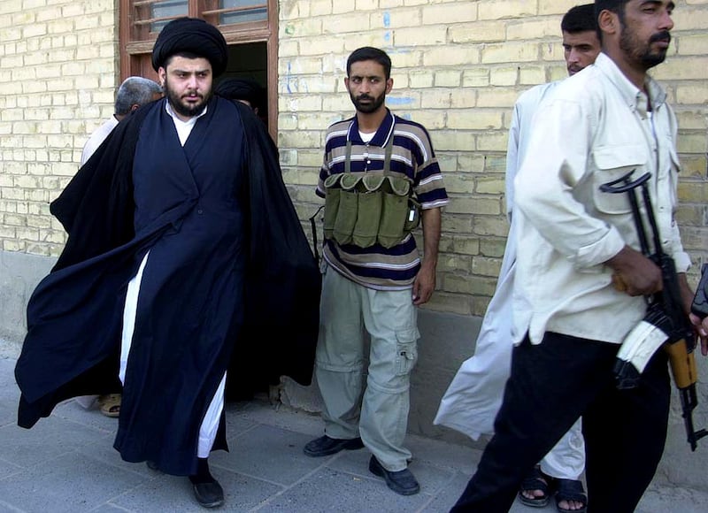 File - In this June 5, 2004 file photo, Shiite cleric Muqtada al-Sadr, left, steps from an office building in Najaf, Iraq.  Iraqâ€™s electoral commission says a political coalition led by influential Shiite cleric Muqtada al-Sadr has won the most seats in Iraqâ€™s national parliamentary elections, according to the release of complete results. (AP Photo/Khalid Mohammed, File)