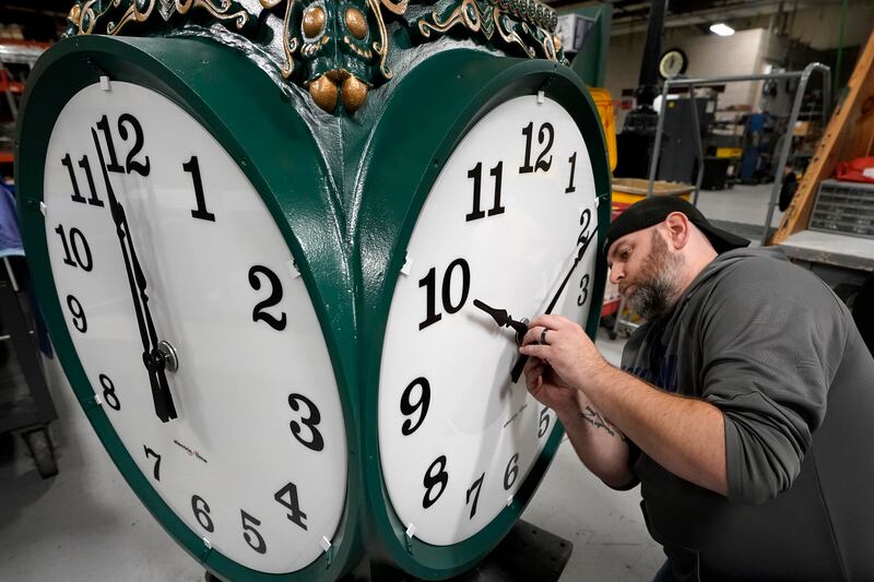 Clock technician Dan LaMoore adjusts clock hands on a large outdoor clock under construction at Electric Time Company in Massachusetts. AP