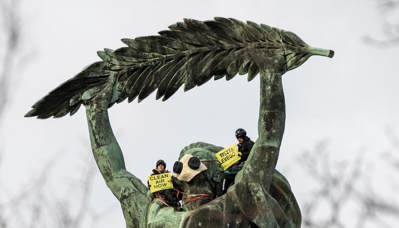 Environmental activists of Greenpeace demonstrate against the capitals air pollution on the statue of Freedom in Budapest, Hungary. EPA