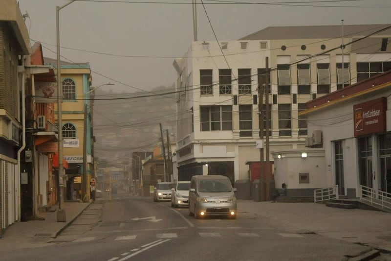 Cars drive along roads covered in ash in Kingstown. About 16,000 people have fled the eruption. Reuters