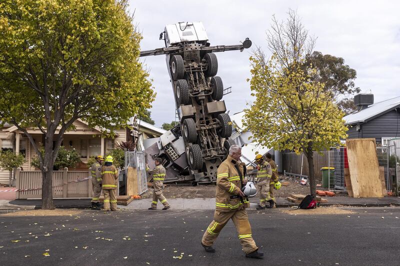 A mobile crane rests on one end after it toppled over onto two houses in Yarraville, Melbourne, Australia. EPA