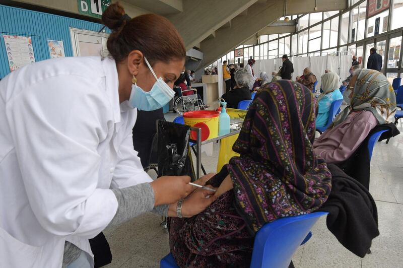An elderly woman receives the Pfizer coronavirus vaccine at El Menzah sports hall in Tunis. AFP