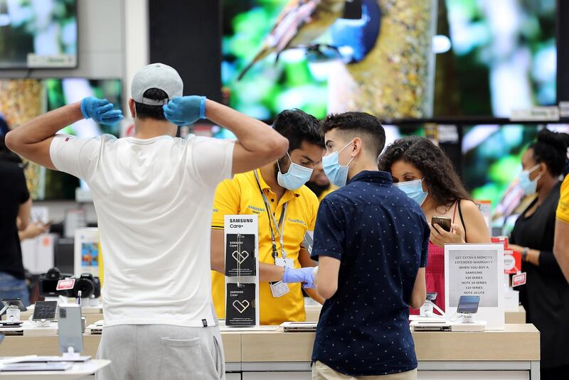 DUBAI, UNITED ARAB EMIRATES , April 29 – 2020 :- Shoppers wearing protective face mask to prevent the spread of the coronavirus at the Sharaf DG store at Mall of the Emirates in Dubai. Authorities ease the restriction for the residents in Dubai. At present mall opening timing is 12:00 pm to 10:00 pm. Carrefour timing is 9:00 am to 10:00 pm. (Pawan Singh / The National) For News/Standalone/Online. Story by Patrick