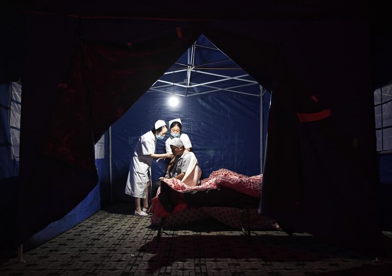 Medical personnel treat an injured man at the People's Hospital in Jiuzhaigou county in southwestern China's Sichuan province. Liu Kun / Xinhua via AP