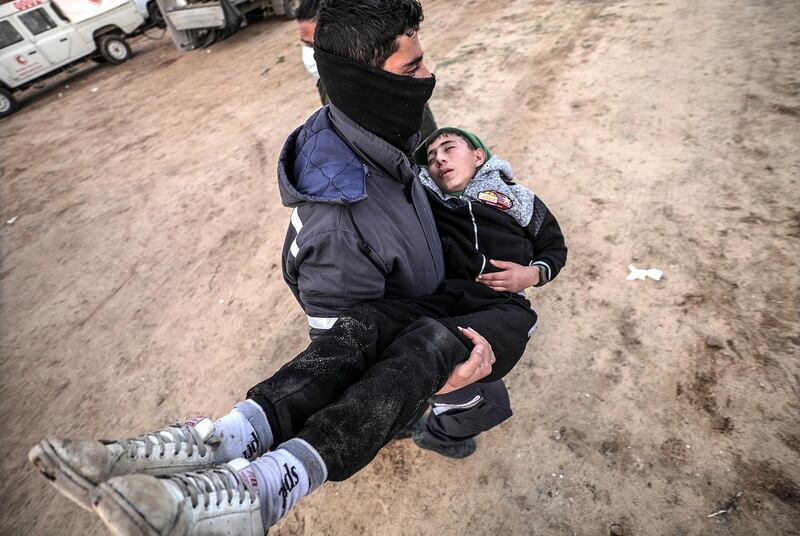 A man carries a wounded boy to a field clinic during clashes near the maritime border between Israel and Gaza Strip, northern Gaza Strip. EPA