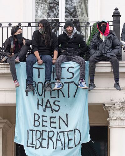 Squatters sit on the edge of a balcony at a Belgravia mansion linked to a Russian oligarch. EPA