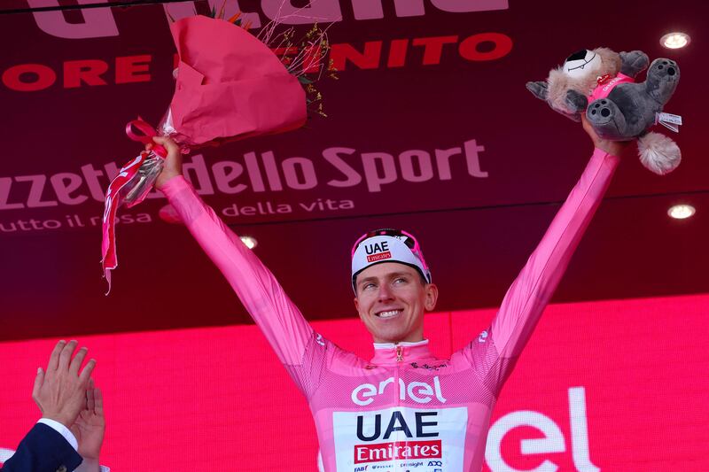 UAE Team Emirates rider Tadej Pogacar celebrates on the podium in his pink jersey after maintaining the overall race lead. AFP