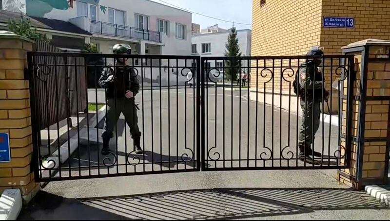 Police officers stand guard near the gates of a school after a shooting in Kazan. AP Photo