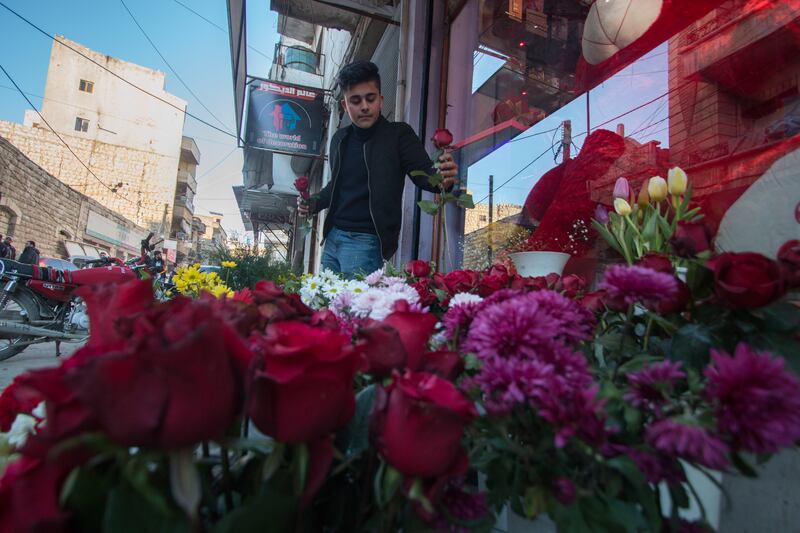 Ahmed, the owner of a flower shop, arranges flowers in front of his shop in preparation for Valentine's Day. All photos: Moawia Atrash / The National