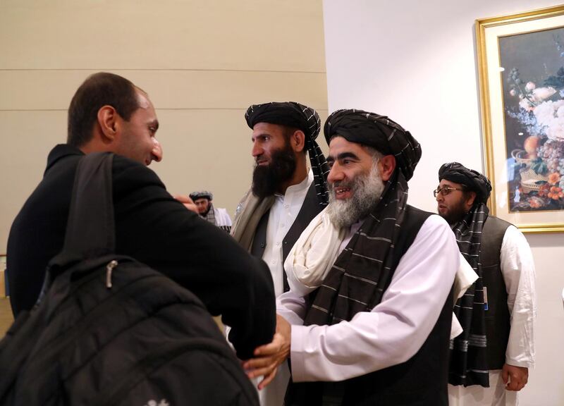 FILE PHOTO: Members of Afghanistan's Taliban delegation (R) gather ahead of an agreement signing between them and U.S. officials in Doha, Qatar, February 29, 2020. REUTERS/Ibraheem al Omari/File Photo