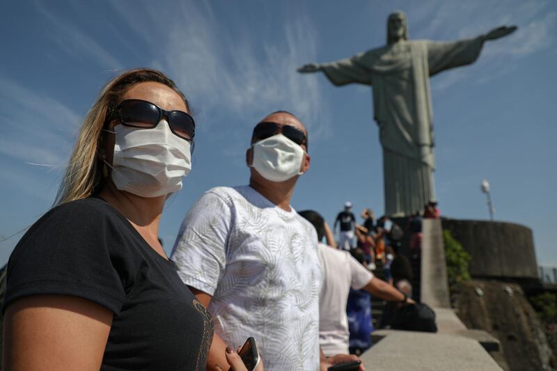 Tourists enjoy a visit to the Christ The Redeemer statue, at the Corcovado Hill, in Rio de Janeiro, Brazil, during the reopening day of touristic attractions in the city amid the pandemic.   AFP