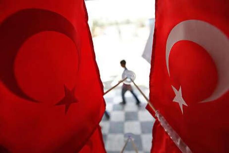 A Palestinian boy walks outside a souvenir shop in Gaza City decorated with Turkish flags. Israeli ministers stressed the importance of mending the country's relations with Turkey after weeks of diplomatic crisis.