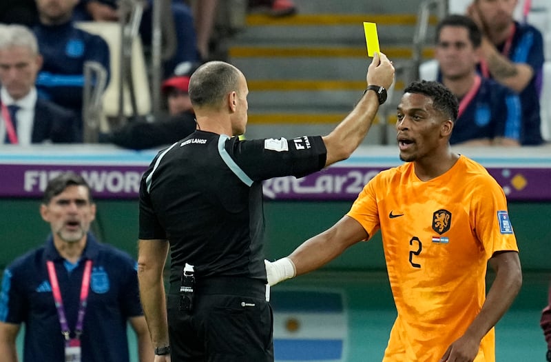 Referee Antonio Mateu shows a yellow card to Jurrien Timber of the Netherlands. AP