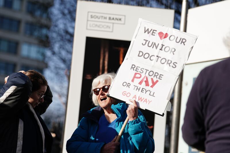 A protester holds up a sign outside St Thomas' Hospital in London. PA