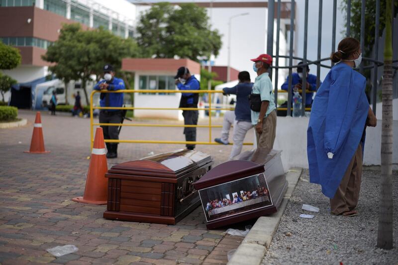 People wait next to coffins outside of Guasmo Sur General Hospital after Ecuador reported new cases of coronavirus disease (COVID-19), in Guayaquil, Ecuador. REUTERS