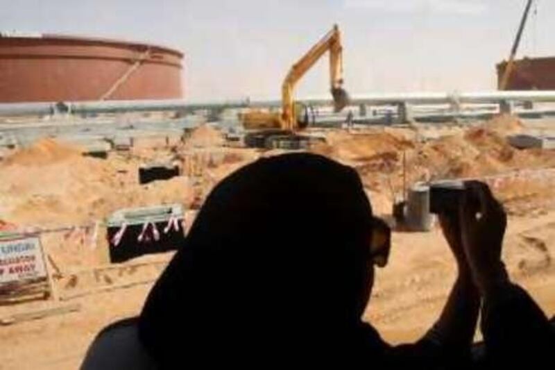 An official takes photographs of the Khurais oilfield, about 160 km (99 miles) from Riyadh, June 23, 2008. State oil giant Saudi Aramco is adamant the biggest new field in its plan to raise oil capacity will arrive bang on schedule in June next year. REUTERS/Ali Jarekji  (SAUDI ARABIA) *** Local Caption ***  SAU12_OIL-KHURAIS-_0623_11.JPG