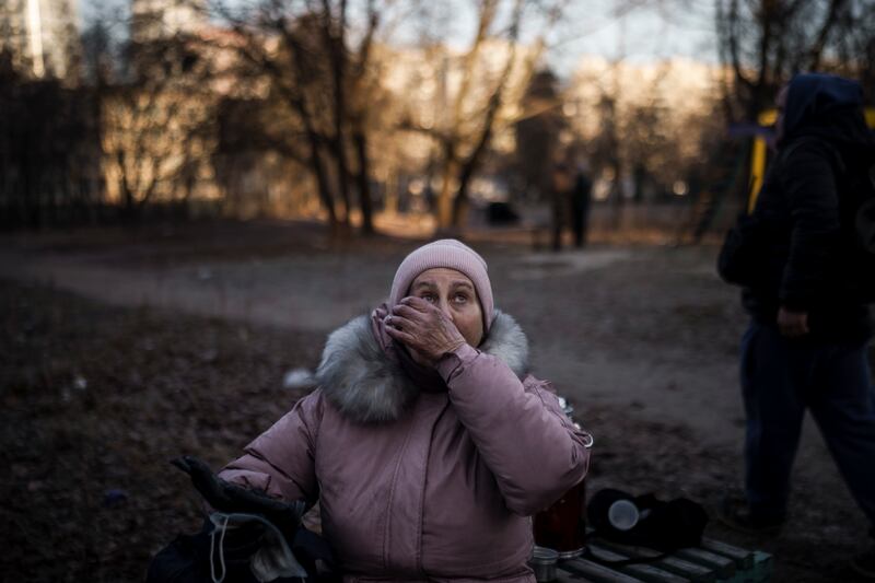 A woman is rescued by firefighters from her apartment in a burning building that was hit by artillery shells in Kyiv. AP