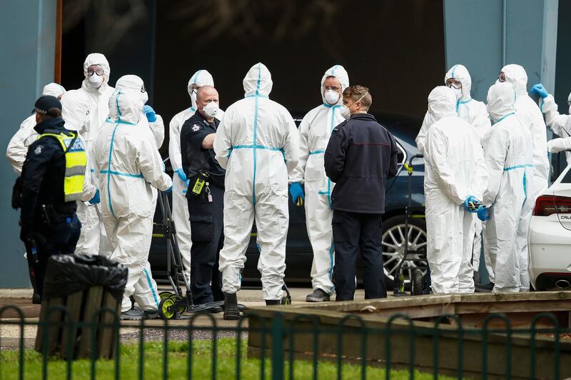 Workers in personal protective equipment are seen alongside police patrols in Melbourne, Australia. Nine public housing towers are placed under lockdown, with a stay-at-home order announced for the whole city starting from Wednesday. Getty Images