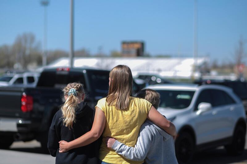 People embrace outside after a shooting at Rigby Middle School in Rigby, Idaho on Thursday, May 6, 2021.  Authorities say a shooting at the eastern Idaho middle school has injured two students and a custodian, and a female student has been taken into custody. (John Roark /The Idaho Post-Register via AP)