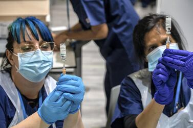Two health professionals preparing coronavirus vaccines. Getty Images