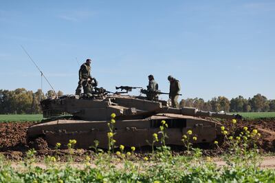 Israeli soldiers stand atop a tank near the border with Gaza in southern Israel. EPA 