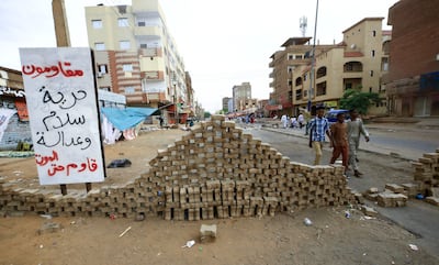 Sudanese protesters stand behind road blocks as they take part in an anti-military demonstration. AFP