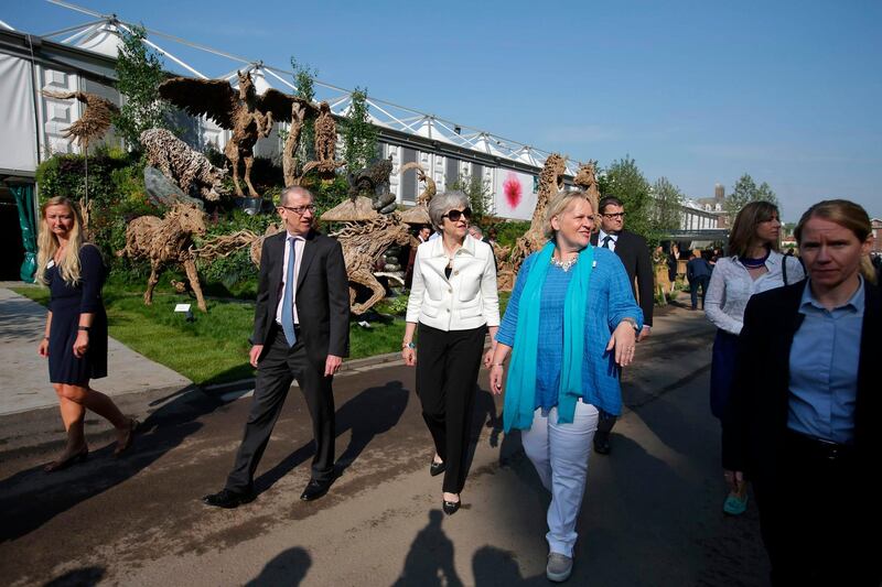Mrs and Mr May are shown around the Chelsea Flower Show by RHS Director General Sue Biggs, second right.