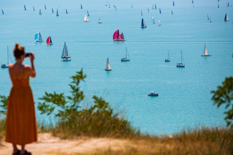 A spectator takes a picture of boats competing in the 52nd Blue Ribbon Round the Lake Balaton Race, near Balatonfured, Hungary, on Thursday, July 30. EPA