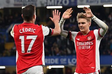 Arsenal's German-born Portuguese defender Cedric Soares (L) and Arsenal's Norwegian midfielder Martin Odegaard (R) celebrate on the final whistle in the English Premier League football match between Chelsea and Arsenal at Stamford Bridge in London on April 20, 2022.  - Arsenal won the game 4-2.  (Photo by Glyn KIRK / AFP) / RESTRICTED TO EDITORIAL USE.  No use with unauthorized audio, video, data, fixture lists, club/league logos or 'live' services.  Online in-match use limited to 120 images.  An additional 40 images may be used in extra time.  No video emulation.  Social media in-match use limited to 120 images.  An additional 40 images may be used in extra time.  No use in betting publications, games or single club/league/player publications.   /  