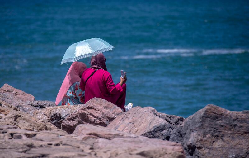 Women sit on the beach during a hot summer day in Rabat, Morocco. EPA