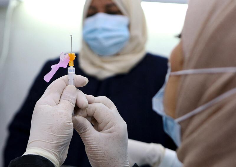 A medic prepares a Pfizer-BioTech COVID-19 vaccine injection at a vaccination centre set up in the Kuwait International Fairground in the capital Kuwait City, on December 24, 2020. - Some Gulf countries have started rolling out their vaccination programmes, with Kuwait and Oman announcing they will start inoculating people with the Pfizer-BioNTech vaccine today and December 27, respectively. (Photo by YASSER AL-ZAYYAT / AFP)