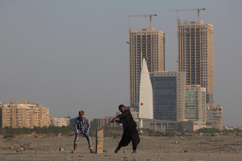 People play cricket with the Hyperstar shopping mall and under construction buildings in the background, in Karachi, Pakistan November 20, 2017. REUTERS/Akhtar Soomro