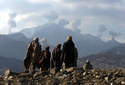 Anti-Taliban Afghan fighters watch several explosions from U.S. bombings in the Tora Bora mountains in Afghanistan December 16, 2001. [Hundreds of al Qaeda fighters have battled to the death in a last stand in eastern Afghanistan, but their leader Osama bin Laden eluded the U.S. dragnet, Afghan commanders said on Sunday.]