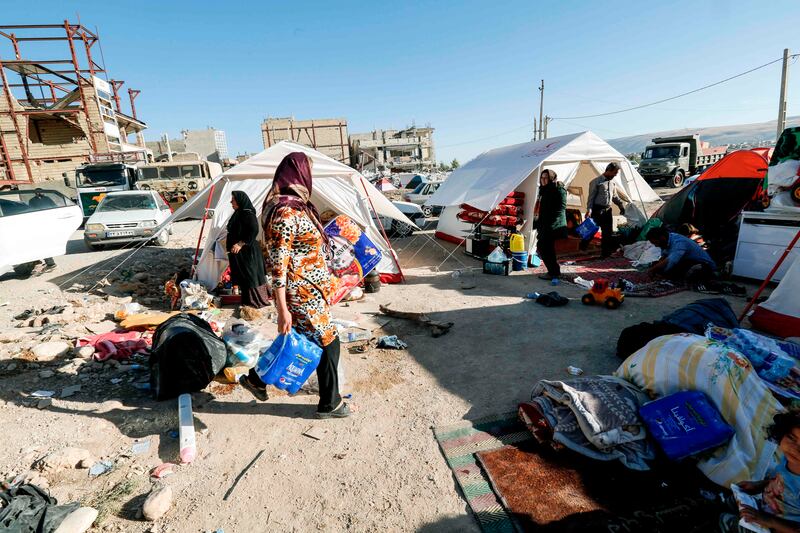 Iranians camp in tents and make-shift shelters outside near damaged buildings in the town of Sarpol-e Zahab in the western Kermanshah province near the border with Iraq, on November 14, 2017, following a 7.3-magnitude earthquake that left hundreds killed and thousands homeless two days before. / AFP PHOTO / ATTA KENARE