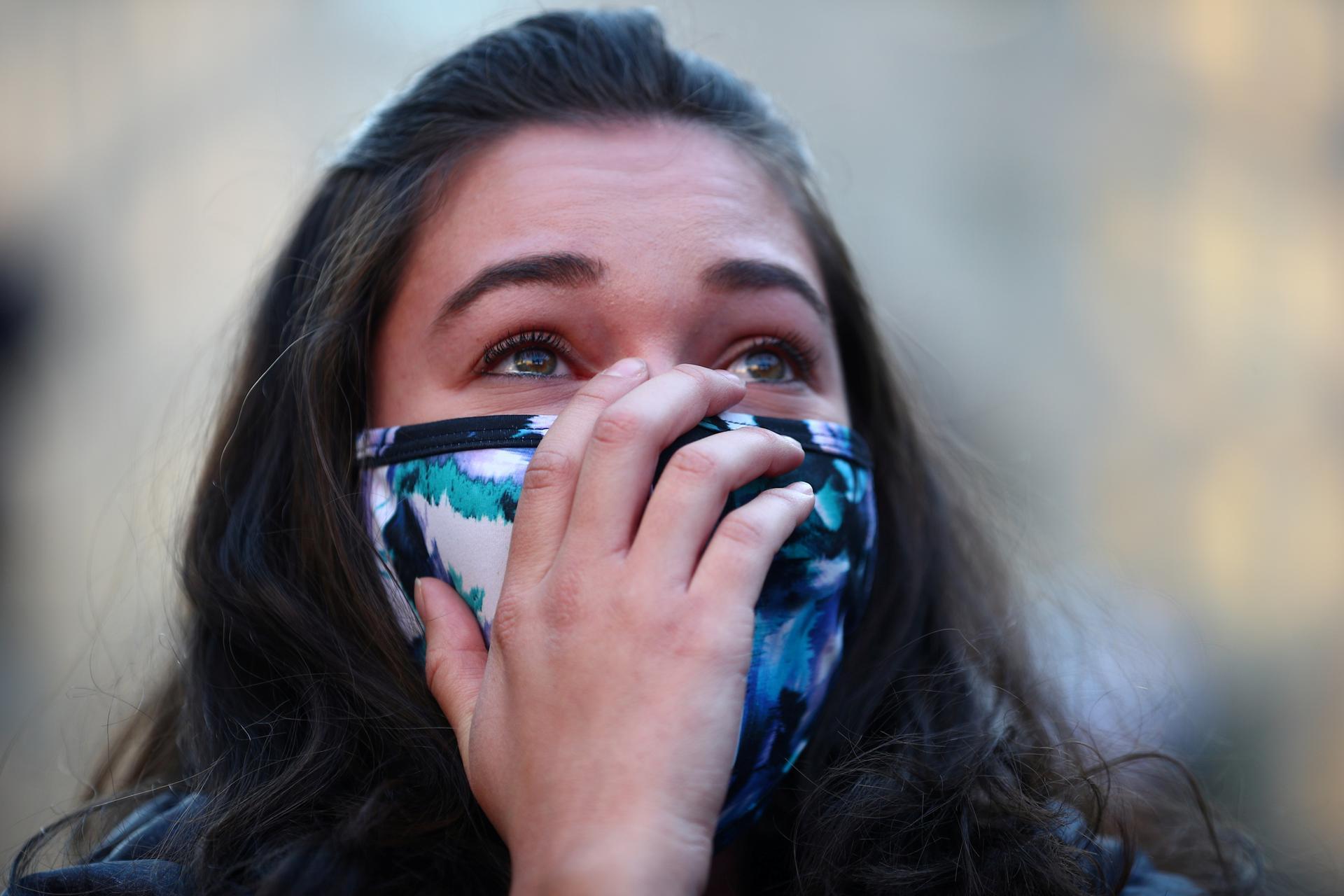 A woman reacts at the news of Democratic US presidential nominee and former Vice President Joe Biden winning Michigan, near the White House after Election Day in Washington. Reuters