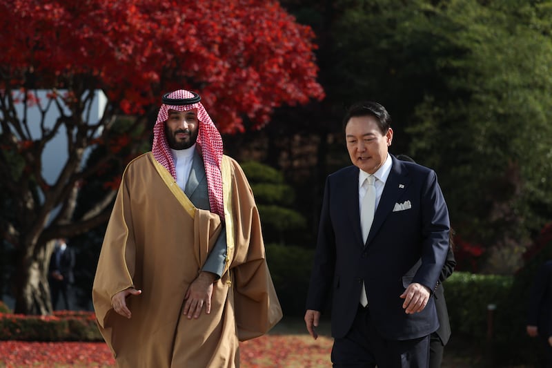 Crown Prince Mohammed and Mr Yoon stroll in the grounds of the presidential residence after their meeting. EPA