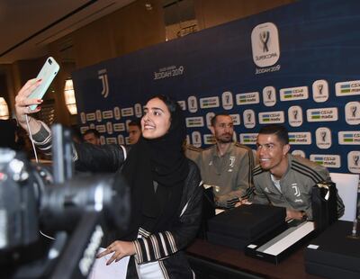 JEDDAH, SAUDI ARABIA - JANUARY 15:  Cristiano Ronaldo of Juventus signing autographs and taking selfie during a meet and greet on January 15, 2019 in Jeddah, Saudi Arabia.  (Photo by Claudio Villa/Getty Images for Lega Serie A)