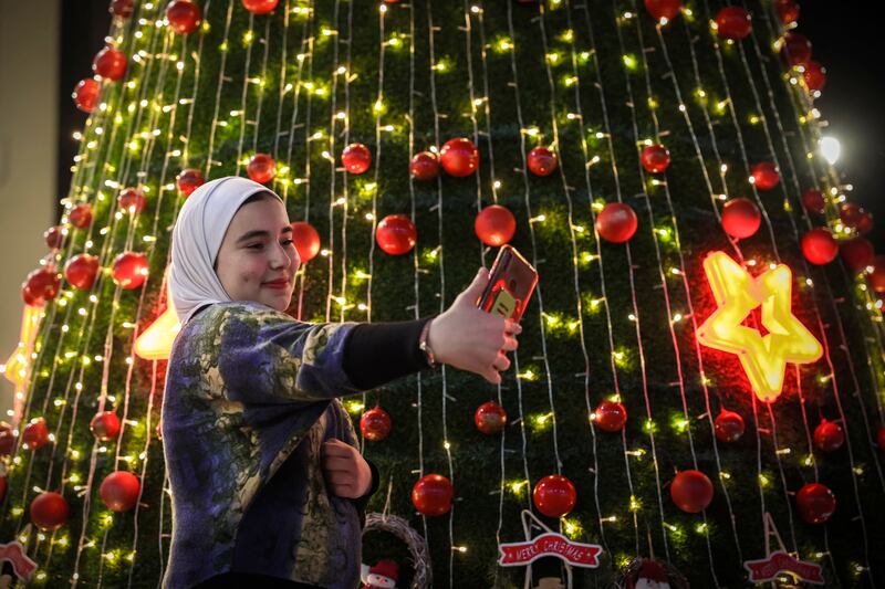 A Palestinian takes a selfie near a Christmas tree in Gaza city. AFP