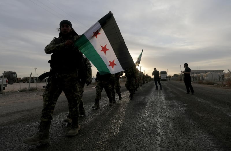 A Turkey-backed Syrian rebel fighter holds the Syrian opposition flag in the border town of Akcakale in Sanliurfa province, Turkey. Reuters