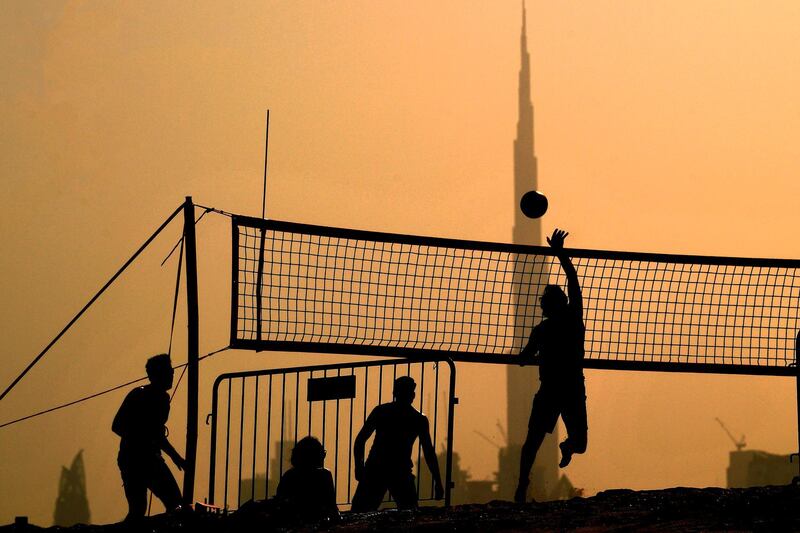People play during a beach volleyball tournament in Dubai.  AFP