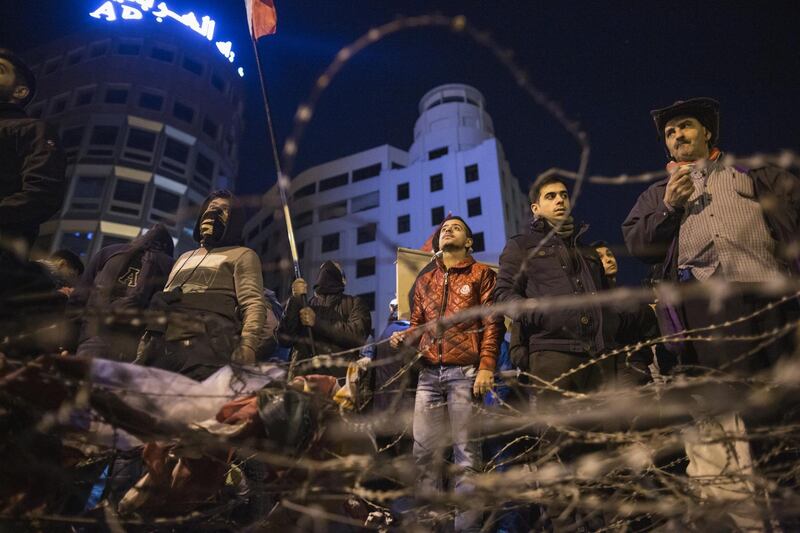 Anti-government protesters stand behind a razor wire barricade near the Grand Serail on January 25, 2020 in Beirut, Lebanon. Getty Images